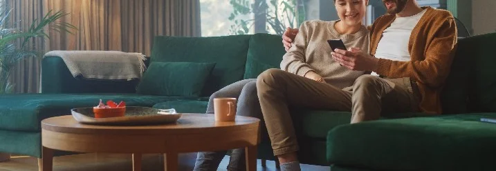 Paar schaut gemeinsam auf das Display eines Smartphones